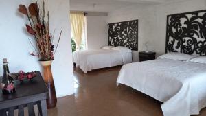 a bedroom with two beds and a table with flowers at Centro Ecoturístico Rancho Buenavista in Nanacamilpa