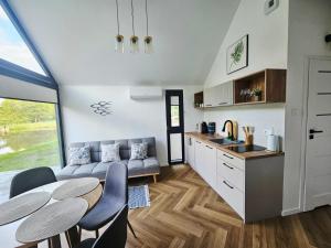 a kitchen and a living room with a table and chairs at STAW się tu in Młyny