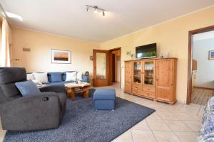 a living room with a couch and a tv at Haus "Luv und Lee" Appartement LUV34 in Döse
