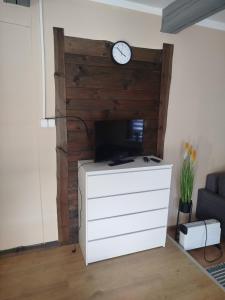 a living room with a clock on a wooden wall at Zakątek Wejsuny in Ruciane-Nida