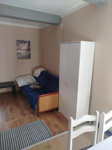 a small bedroom with a bed and a white cabinet at Zakątek Wejsuny in Ruciane-Nida