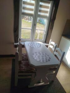 a table and chairs in a room with a window at Zakątek Wejsuny in Ruciane-Nida