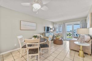 a living room with a table and chairs and a couch at Plantation East #2310 in Gulf Highlands