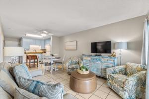 a living room with a couch and a tv at Plantation East #2310 in Gulf Highlands
