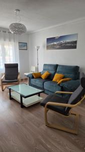 a living room with a blue couch and a table at Vivienda Mirasierra in Béjar