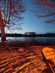 a picnic table and bench next to a lake at Zakątek Wejsuny in Ruciane-Nida