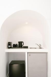 a kitchen counter with a sink and a microwave at Anemos Fira Caldera View in Fira