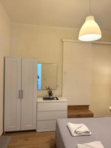 a bedroom with a bed and a cabinet and a mirror at Spiros apartment - Loggos, Paxos in Longós +3 photos