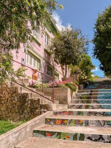 a pink building with stairs and flowers in front of it at Casa Om Shanti in Passa Quatro