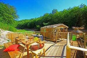a deck with a picnic table and a gazebo at Camping 3 étoiles - Piscine - ccbfh0d in Saint-Amand-de-Coly