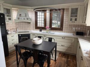 a kitchen with a table and a sink and a stove at M Villa Pelion in Tsagarada