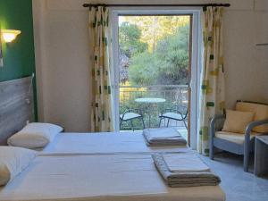 a bedroom with two beds and a balcony with a view at Hermes in Agia Marina Aegina
