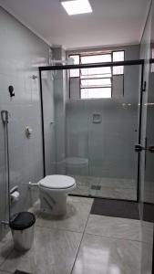 a bathroom with a glass shower and a toilet at Confortável & Bem Localizado! in Campo Grande