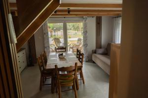 a dining room with a table and chairs and a couch at Domek letniskowy in Klusek Biały