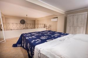 a bedroom with a bed with a blue and white blanket at Ciccio's House in Giardini Naxos