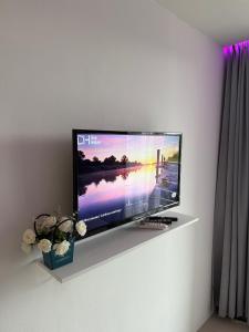 a flat screen tv sitting on a wall at Sunset view apartment with a pool MAIKHAO Phuket in Ban Mai Salae