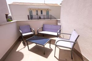 two chairs and a table on a balcony at Ciccio's House in Giardini Naxos