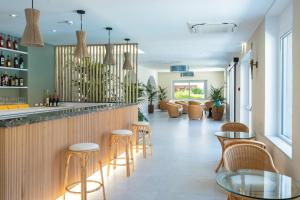 a bar in a restaurant with chairs and tables at Hotel Giardino La Playa - Adults Only in Alghero