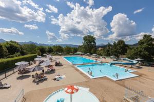 a large swimming pool with people sitting around it at Camping 3 étoiles - Piscine - ccbgaae in Mens