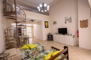 a living room with a staircase and a living room with a bed at Ciccio's House in Giardini Naxos