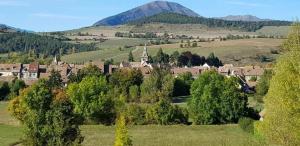 a small town in a field with mountains in the background at Camping 3 étoiles - Piscine - ccbgaae in Mens