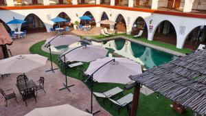 an overhead view of a pool with tables and umbrellas at Hotel Hacienda Bugambilias La Paz in La Paz +14 photos