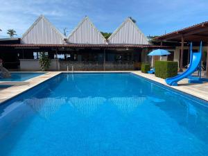 a blue swimming pool with a slide in front of a building at Hotel Oasis Beach Club in Puntarenas
