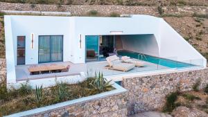 a villa with a swimming pool and a house at Anemolia Villas in Karpathos