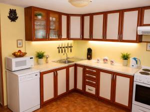 a kitchen with wooden cabinets and white appliances at Chata Adrian Slovak Paradise in Spišské Tomášovce +23 photos