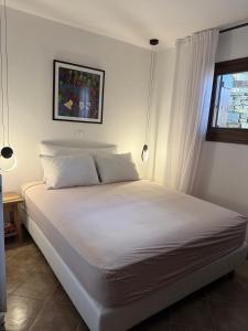 a white bed in a bedroom with a window at M Villa Pelion in Tsagarada
