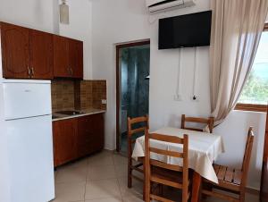 a kitchen with a table and a white refrigerator at Aparthotel Fitimi in Borsh