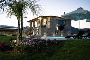 a villa with a pool and a house with an umbrella at Villa Arancia in Argos
