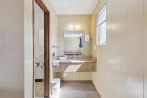 a bathroom with a sink and a mirror at Currys Motel by OYO Saginaw MI in Saginaw +27 photos