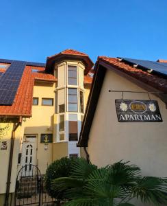 a building with a sign on the side of it at Era Apartmanház in Harkány