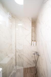 a bathroom with a shower with white marble walls at Nisaki City Vibes in Chios +17 photos