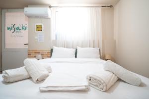 a bedroom with a bed with white sheets and pillows at Nisaki City Vibes in Chios