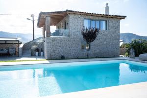 a villa with a swimming pool in front of a house at Villa Arancia in Argos