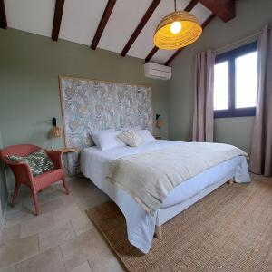 a bedroom with a large white bed and a chair at Mas del Sola in Castelnou