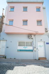 a pink and white building with two doors at Nisaki City Vibes in Chios