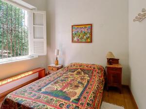 a bedroom with a bed with a colorful blanket on it at Casa Om Shanti in Passa Quatro