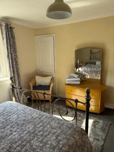 a bedroom with a bed and a dresser and a mirror at Annie Place in Whitby