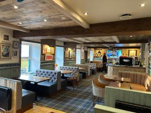 a restaurant with couches and tables and a bar at The Castle Hotel NR TAIN in Portmahomack