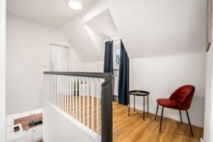 a staircase with a red chair and a table at Feriwnohung Liv OG in Rechlin