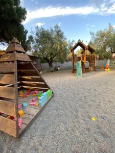 a playground with a wooden play structure and a play set at Nisi Glamping in Paralia Rachon