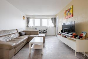 a living room with a couch and a flat screen tv at petit cocon in Créteil