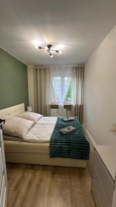 a bedroom with a bed with a table in it at Vespera Apartment - Retkinia in Łódź +13 photos