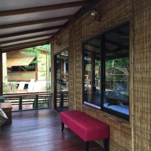 a red bench in a room with windows at Phoxay Ngam Resort in Vang Vieng