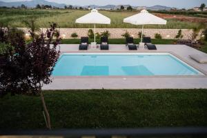 a swimming pool with chairs and umbrellas at Villa Arancia in Argos