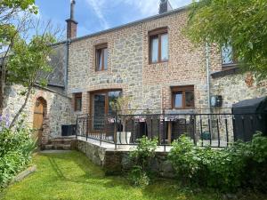 an old brick house with a fence in the yard at Gîte Les Aubennes in Fromelennes