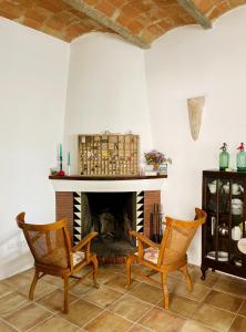 a living room with two chairs and a fireplace at NEW - Casa Palamós - Charming historical home with patio, in the heart of the old town, 100m from beach in Palamós